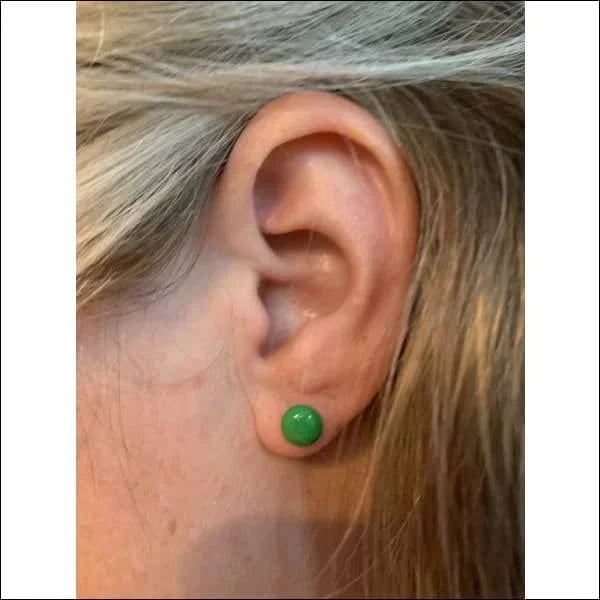 Een vrouw met een groene oorpiercing