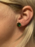 Vrouw Met Groene Zirkonia Stalen Oorknopjes Van 10mm.