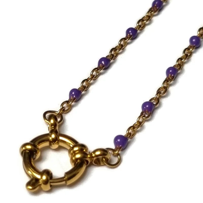 Een ketting met een gouden ketting en paarse kralen