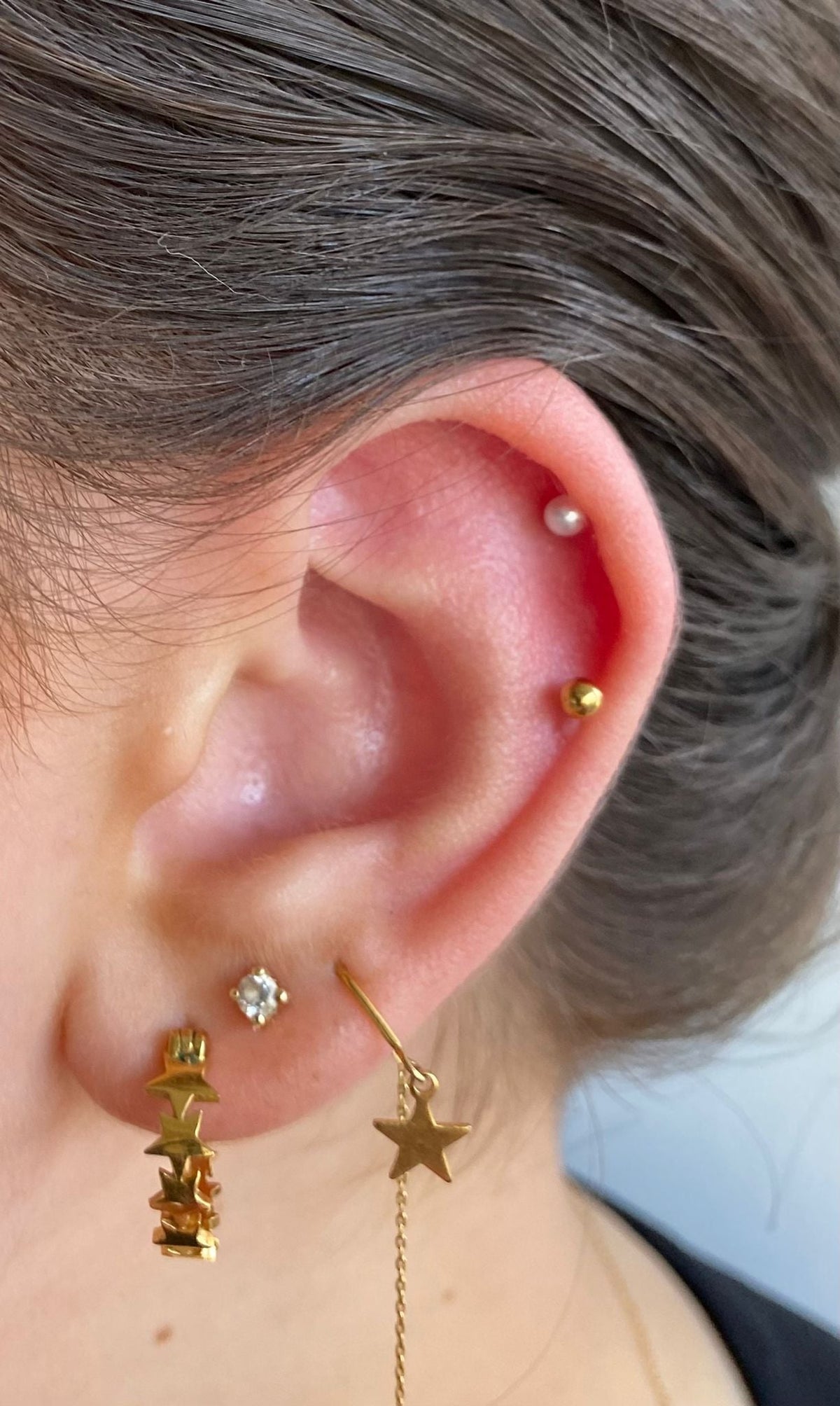 Vrouw Draagt Goudkleurige Ster Tragus Piercing - Chirurgisch Staal