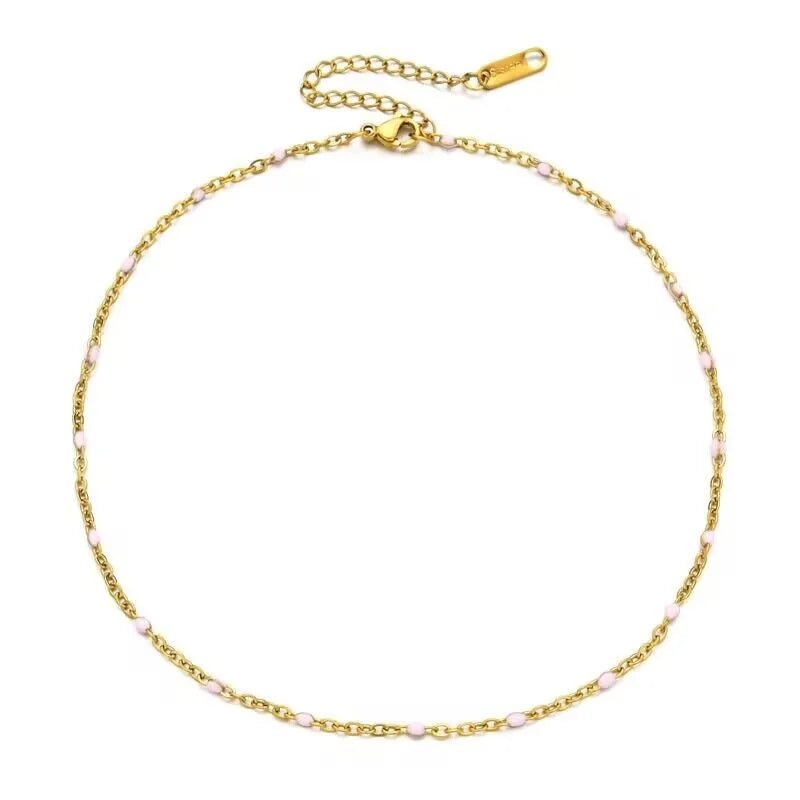 Een gouden armband met roze kralen en een gouden ketting