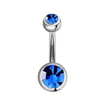 Zilveren navelpiercing met blauwe edelstenen.