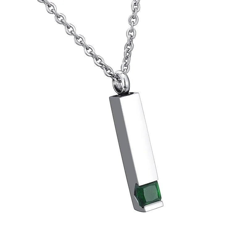 Een rechthoekige hanger met een groene steen aan een ketting