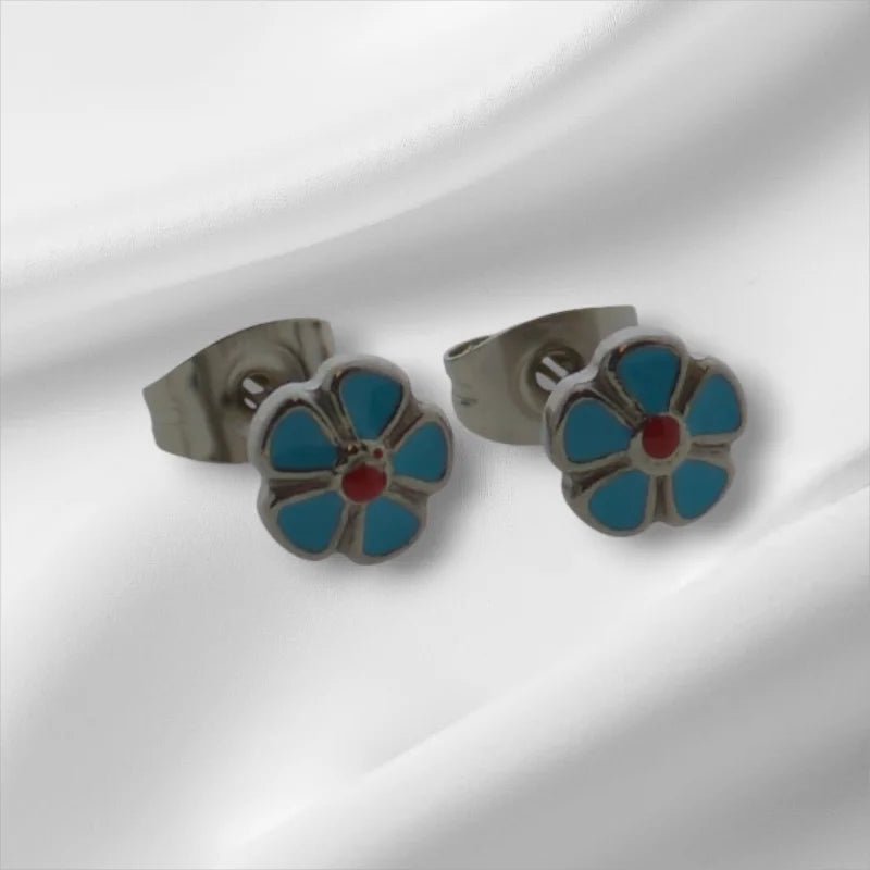 Bloemvormige oorbellen met turquoise bloemblaadjes en een rood hart.