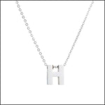 Een halsketting met witte letters en een zilveren ketting