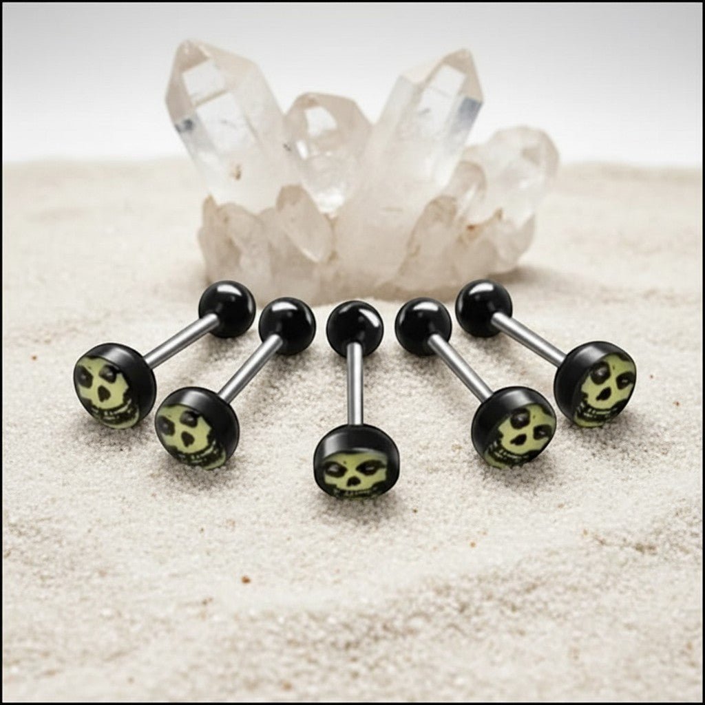 Aramat Jewels surgical steel tongue piercing with black acrylic balls and a skull logo design.