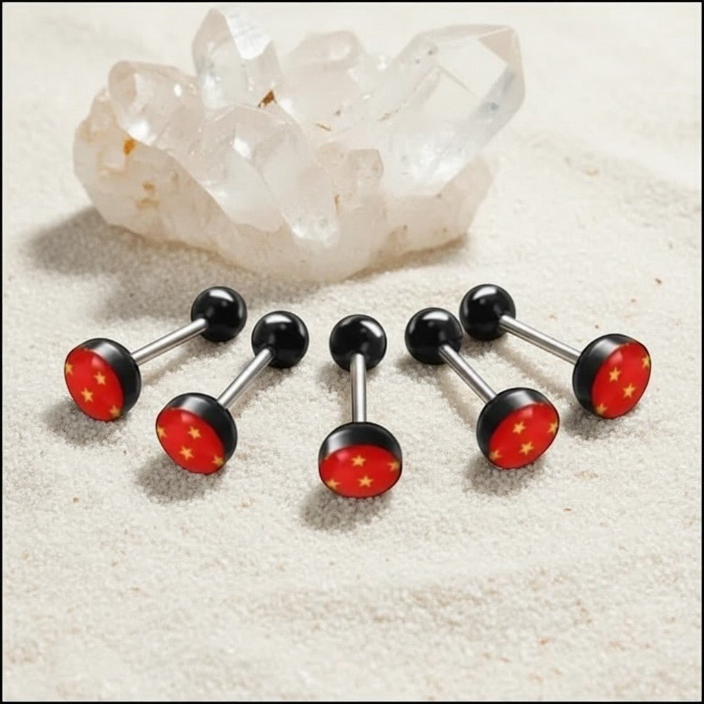 Aramat Jewels surgical steel tongue piercing with black acrylic balls and a red acrylic logo featuring yellow stars.