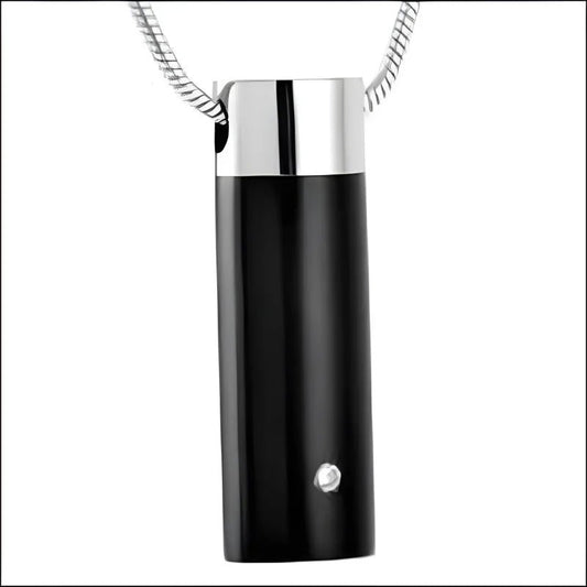 Een zwart met zilveren halsketting met een zwarte cilindervormige hanger