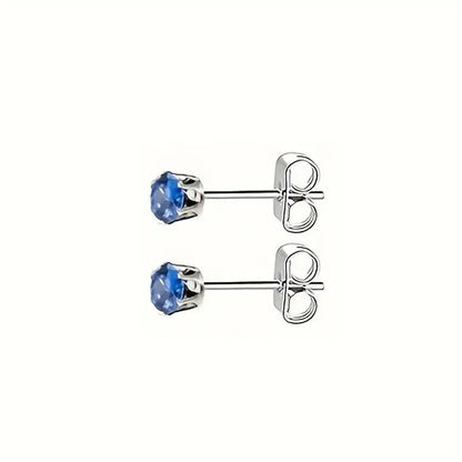 Paar zilveren oorbellen met blauwe edelstenen.