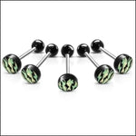 Een set van vier chirurgische piercings met camouflageprint in zwart en groen