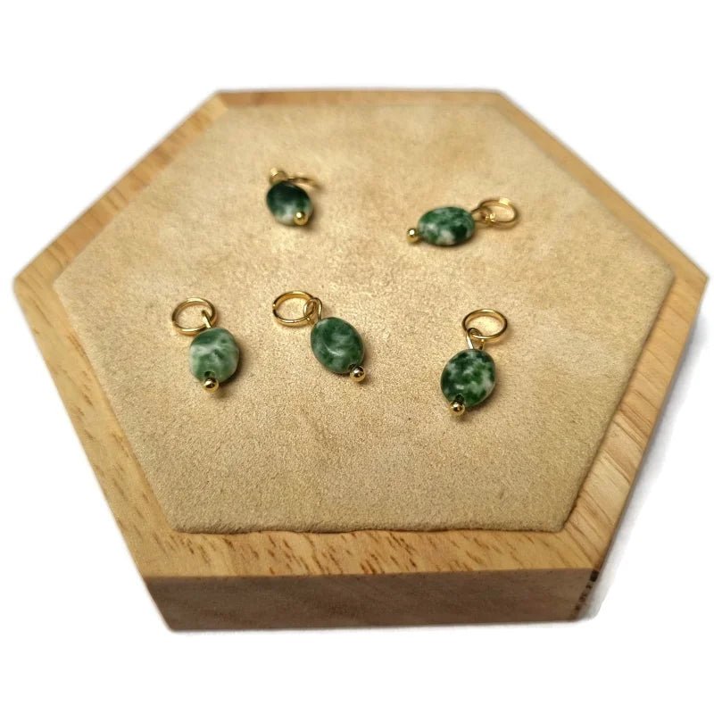 Een paar oorbellen van groene jade op een houten doosje