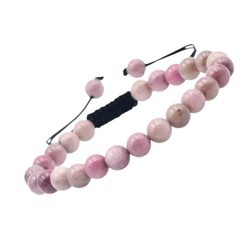 Een roze armband met een zwart koord