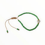 Een groene bea-armband met een gouden sluiting