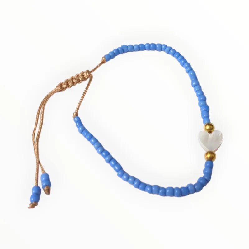 Een blauwe armband met een gouden bea en een witte bea