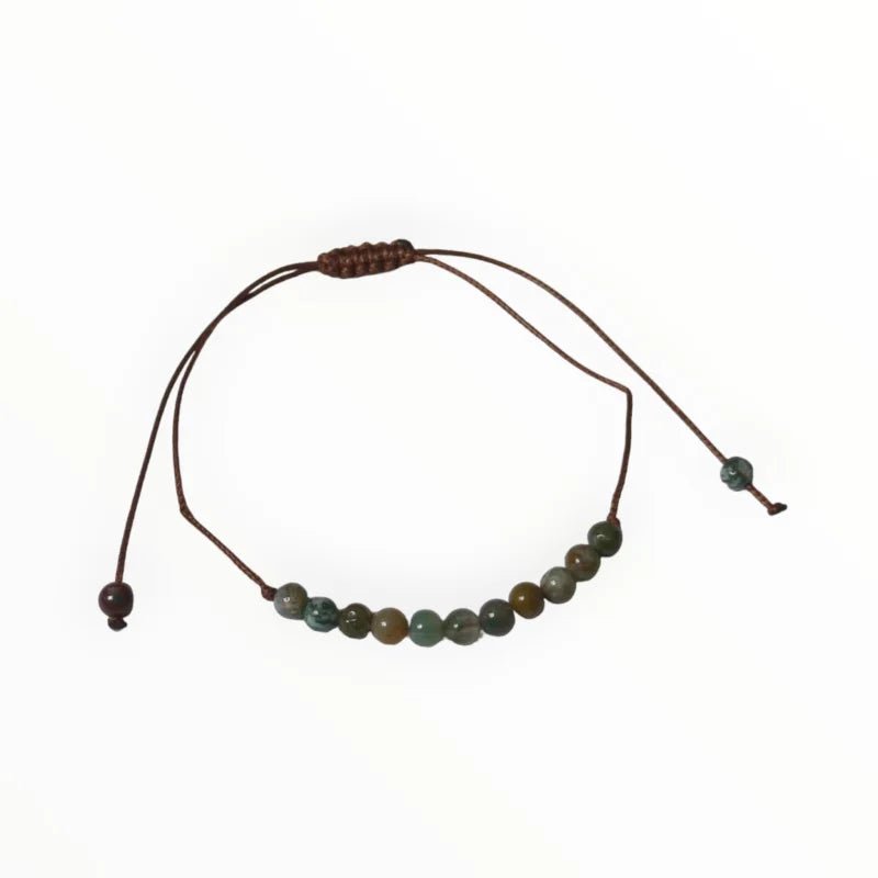 De armband is gemaakt van één streng groene jadekralen en één streng bruin leren koord