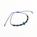 Een blauwe armband met een gouden bea en een blauw boze oog