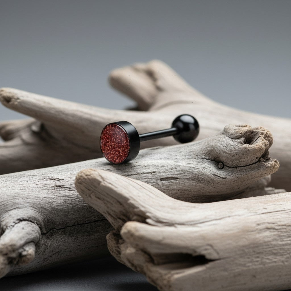 Aramat Jewels black bioplast tongue piercing with a red glitter top and black ball end.