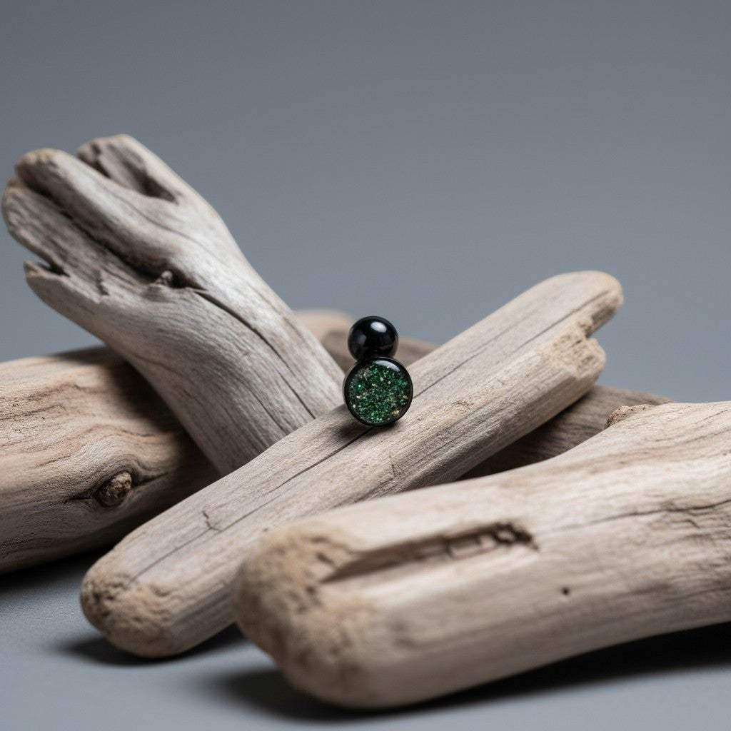 Aramat Jewels black bioplast tongue piercing with a green glitter ball.