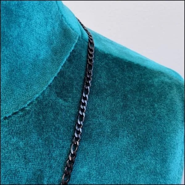 Een close-up van een zwarte ketting op een blauw shirt